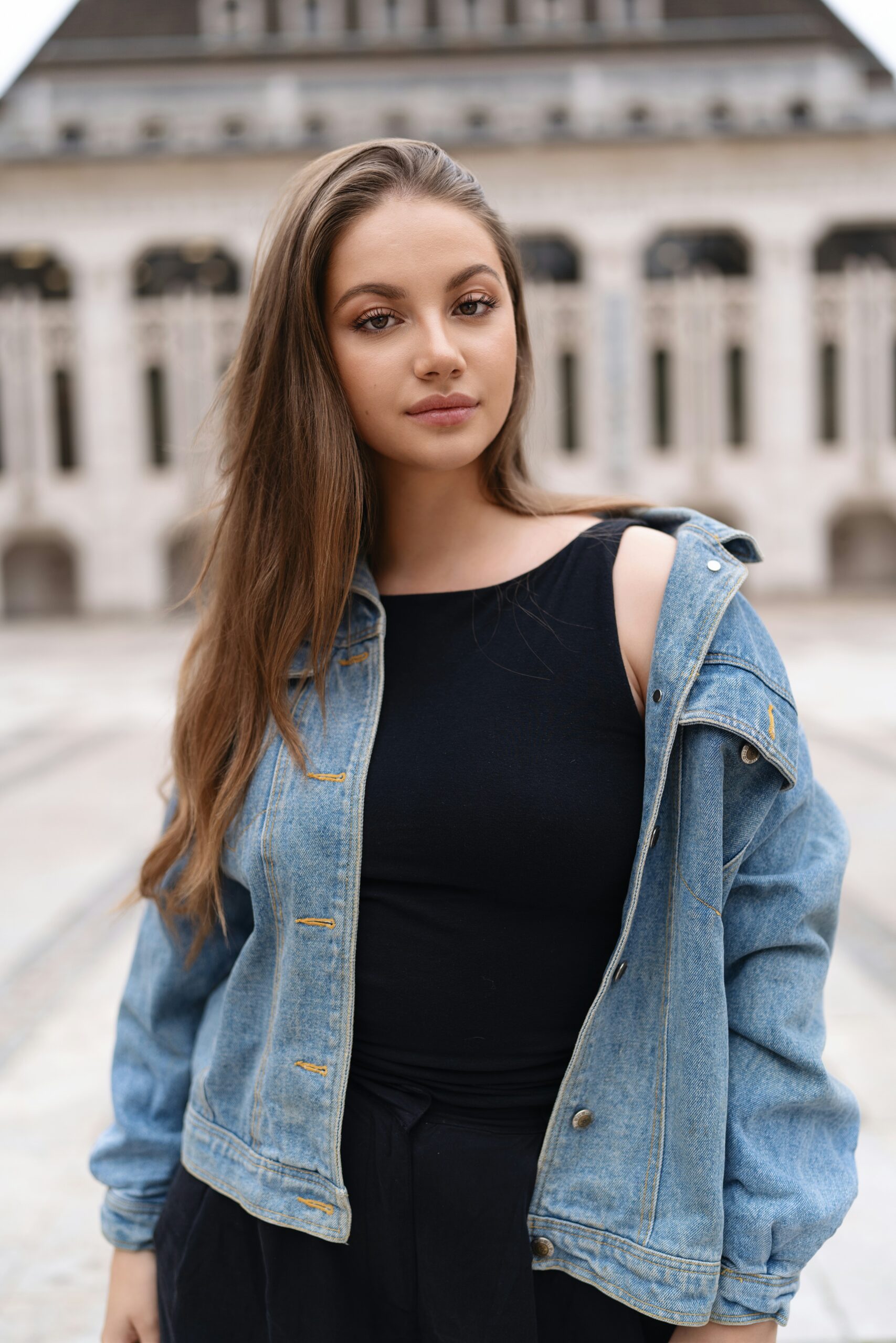 A woman standing in front of a large building